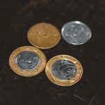 moedas de prata e ouro em uma superfície preta.