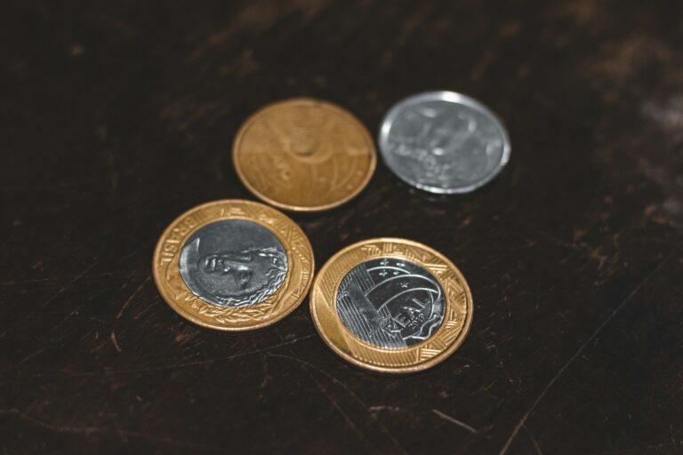 moedas de prata e ouro em uma superfície preta.